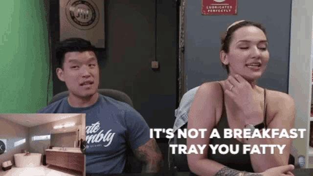 a man and a woman are sitting at a table and the woman says it 's not a breakfast tray
