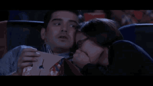 a man and a woman are watching a movie in a theater