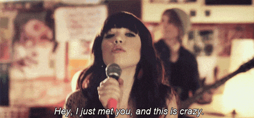 a woman singing into a microphone with the words " hey i just met you and this is crazy "