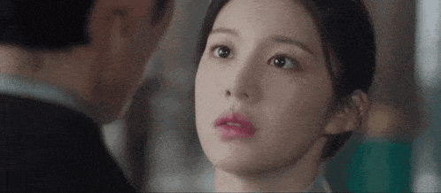 a man and a woman are looking at each other . the woman is wearing pink lipstick .