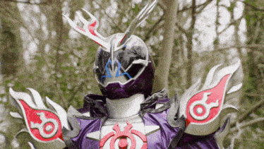 a close up of a purple and white costume with a red eye on the shoulder