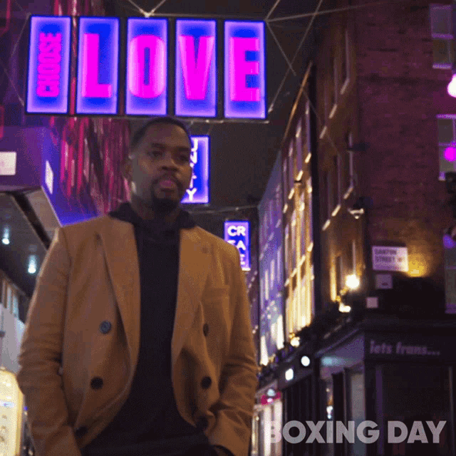 a man stands in front of a love sign