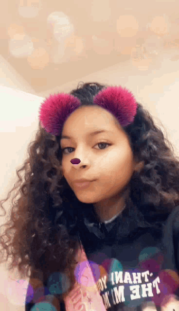 a girl with curly hair wearing a hoodie that says " boy i want " on it