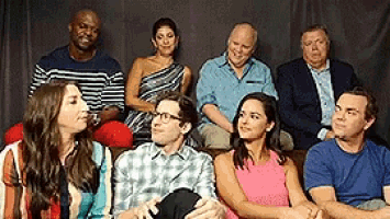 a group of people are sitting next to each other on a couch .