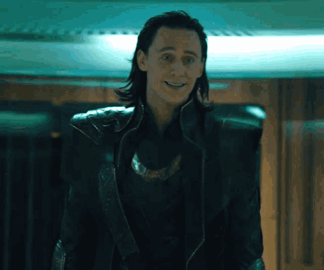 a man with long hair is wearing a black leather jacket