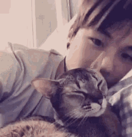 a man is laying in bed with a cat .