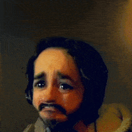a man with a beard wearing headphones making a face