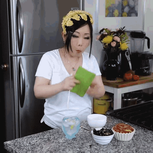 a woman in a white shirt holds a green napkin in her hand