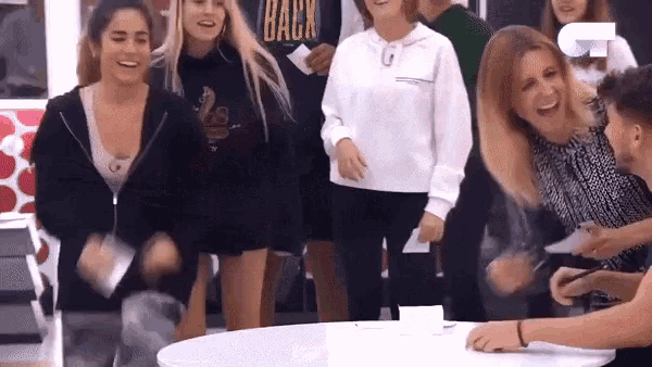 a group of people are laughing and one of them has a shirt that says back