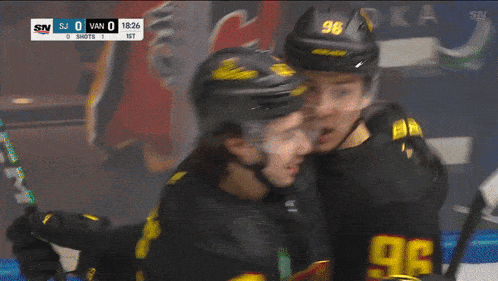 a hockey player wearing a helmet that says nexgen is hugging another player