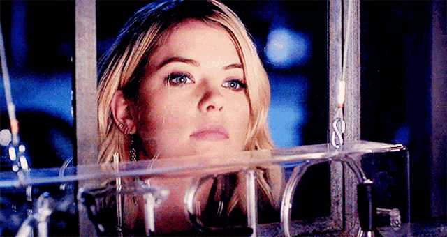 a close up of a woman 's face behind a glass cage