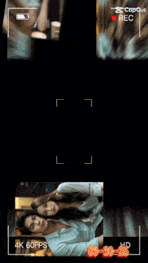 a man and a woman are sitting at a table with a capture button
