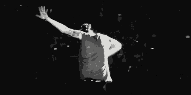 a black and white photo of a man dancing on stage