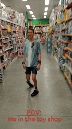 a man in a blue shirt is walking through a toy store