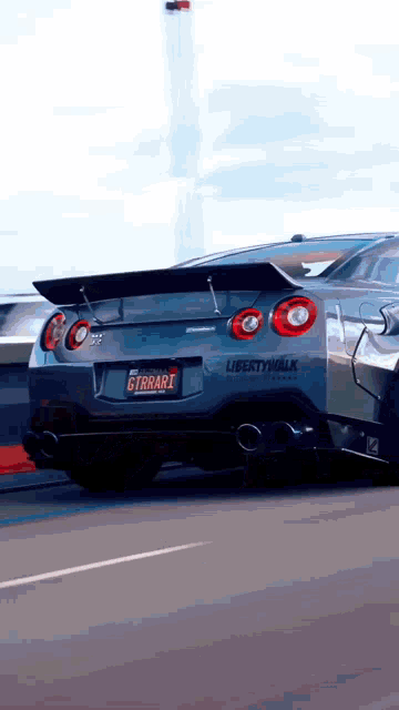 a car with a license plate that says gtrrari is driving down the road