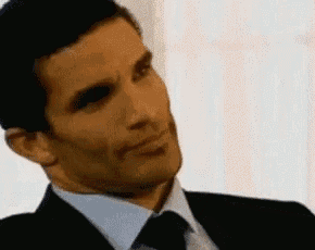 a man in a suit and tie is making a funny face .