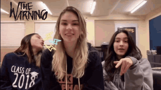 three girls wearing class of 2018 sweatshirts are posing for a photo