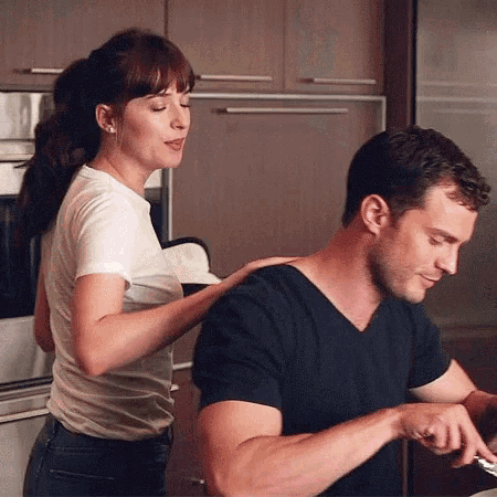 a woman is putting her hand on a man 's shoulder