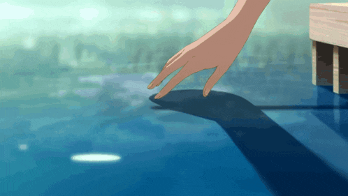a person 's hand is reaching into the water and touching the surface