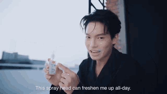 a man in a black robe is holding a spray bottle and saying this spray head can freshen me up all day