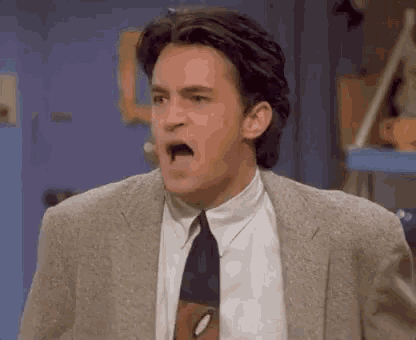 a man in a suit and tie is making a face .