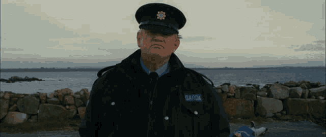 a man in a garda uniform stands in front of the water
