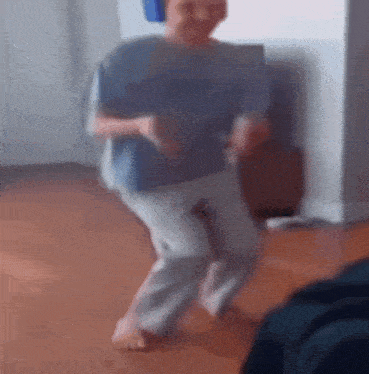 a person is dancing on a wooden floor in a living room .