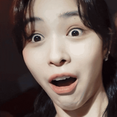 a close up of a woman making a surprised face