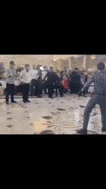 a man is dancing in front of a crowd of people