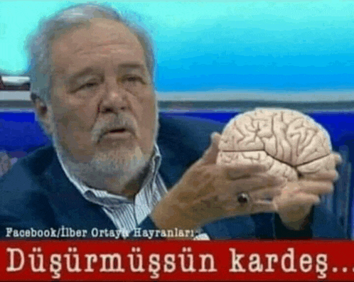 a man with a beard is holding a model of a brain in his hand
