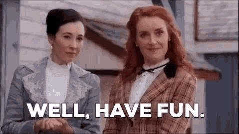 two women are standing next to each other with the words `` well , have fun '' written on the screen .