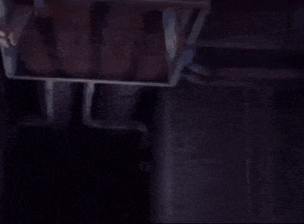 a creepy clown with a long neck is hanging from the ceiling .