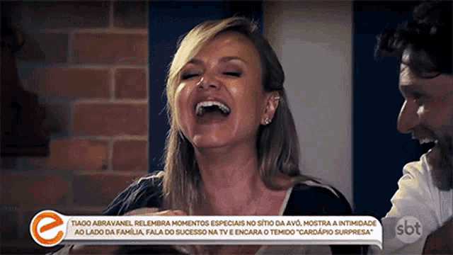 a woman is laughing in front of a sbt advertisement