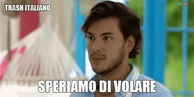 a man with a beard and a blue shirt says " speriamo di volare " in italian