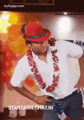 a man wearing a red hat and a flower lei is dancing .