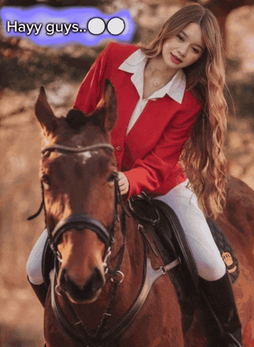a woman in a red jacket is riding a brown horse with the caption hayy guys
