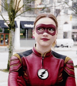 a woman in a flash costume is wearing a red mask