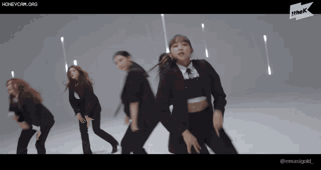 a group of women are dancing in front of a sign that says ' honeycam.org '