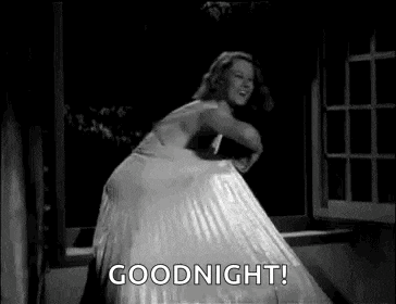 a woman in a white dress is dancing in front of a window and says `` goodnight '' .