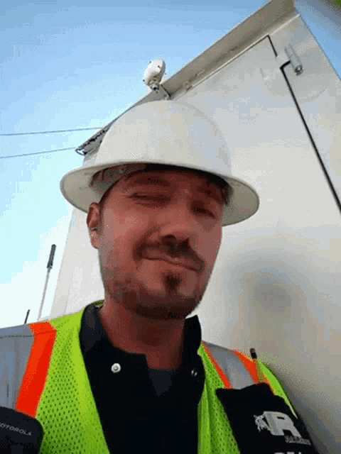 a man wearing a hard hat and a vest with motorola on it