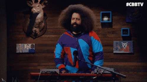 a man with a beard is playing a keyboard and the words jesus christ are above him