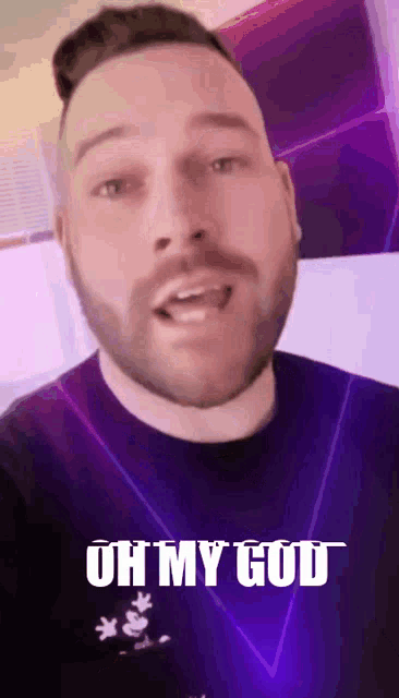 a man with a beard is wearing a purple shirt that says ' oh my god ' on it