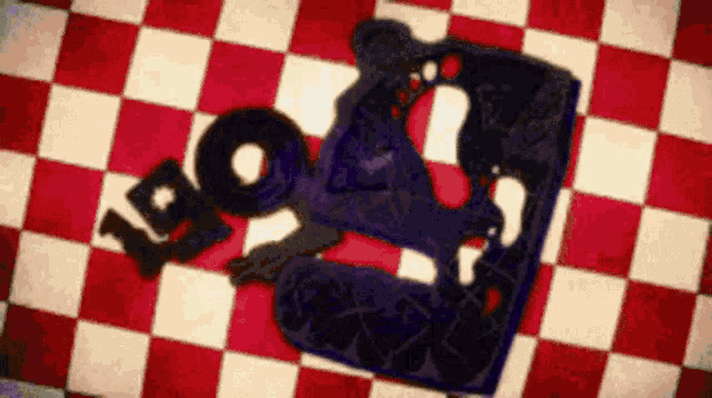 a person is laying on a red and white checkered floor with a piece of paper .