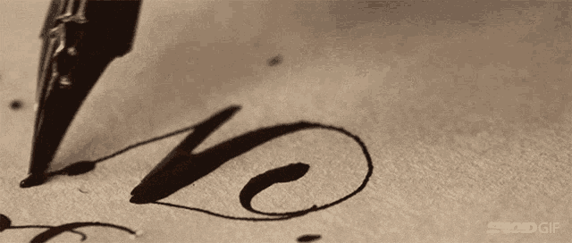 a close up of a pen writing the word love