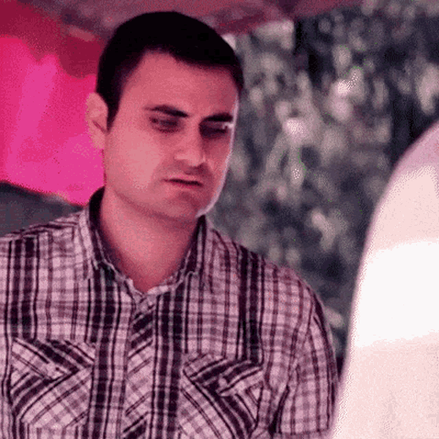 a man in a plaid shirt is looking at someone