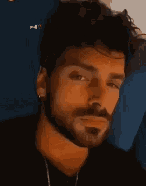 a close up of a man with a beard and a piercing in his nose .