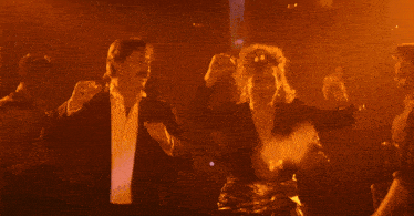 a man and a woman are dancing in an orange room