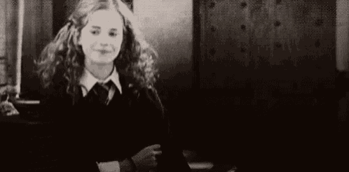 a black and white photo of hermione granger laughing with her mouth open .