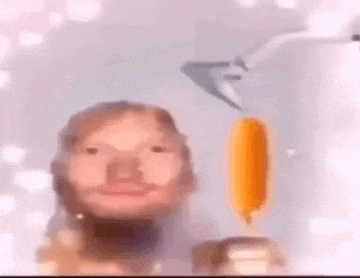 a man with a beard is holding a popsicle in his hand .