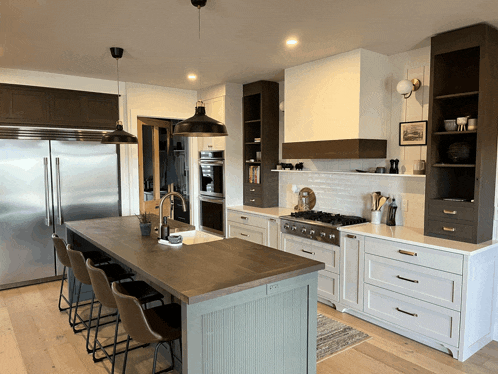 a kitchen with stainless steel appliances and a large island in the middle